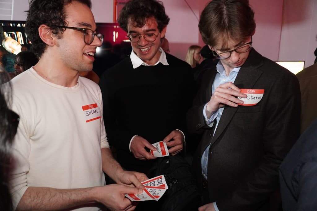 Handwritten name-tag stickers and jokes at the mingle.